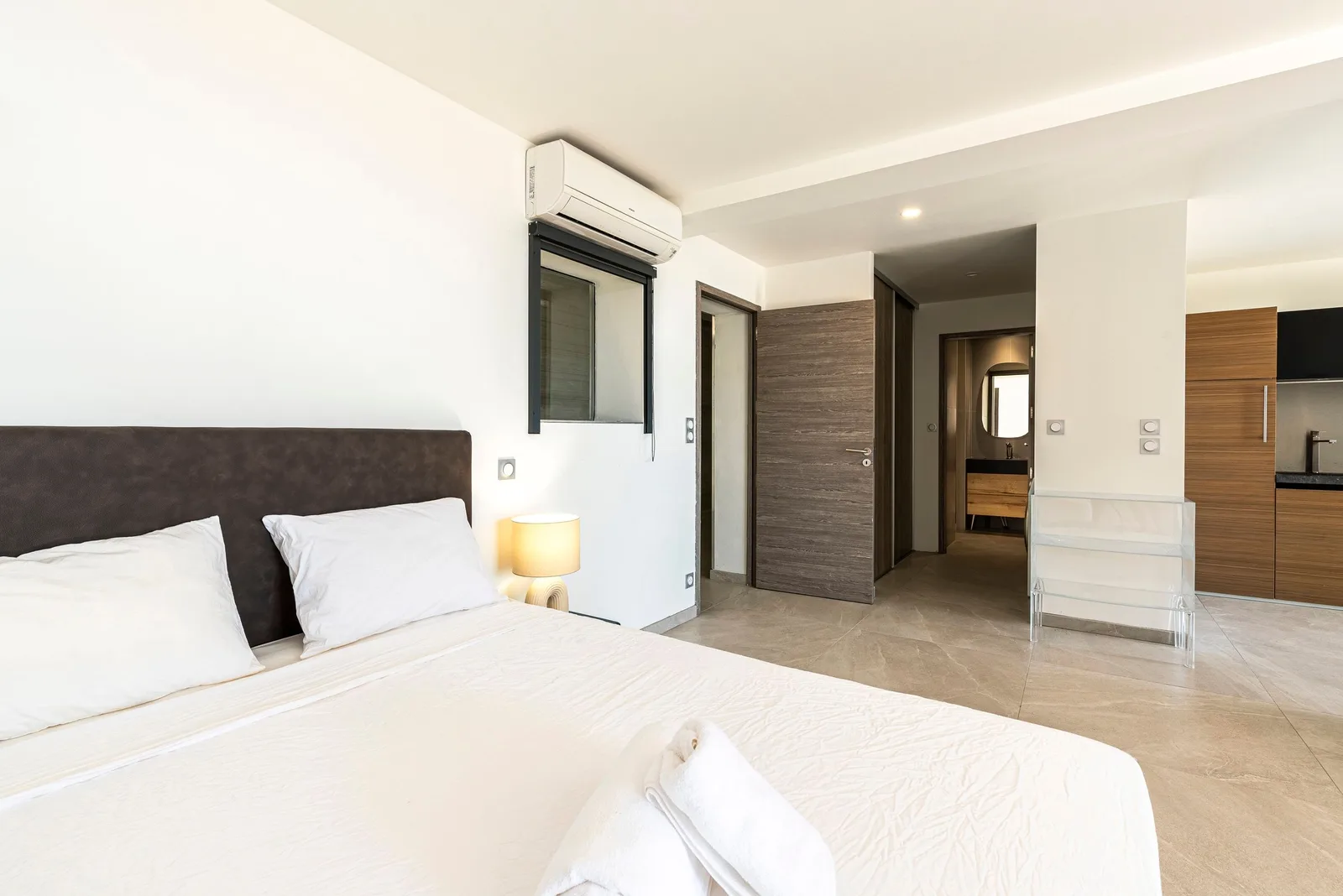 Lit double du studio, climatisation murale et salle d'eau attenante avec kitchenette