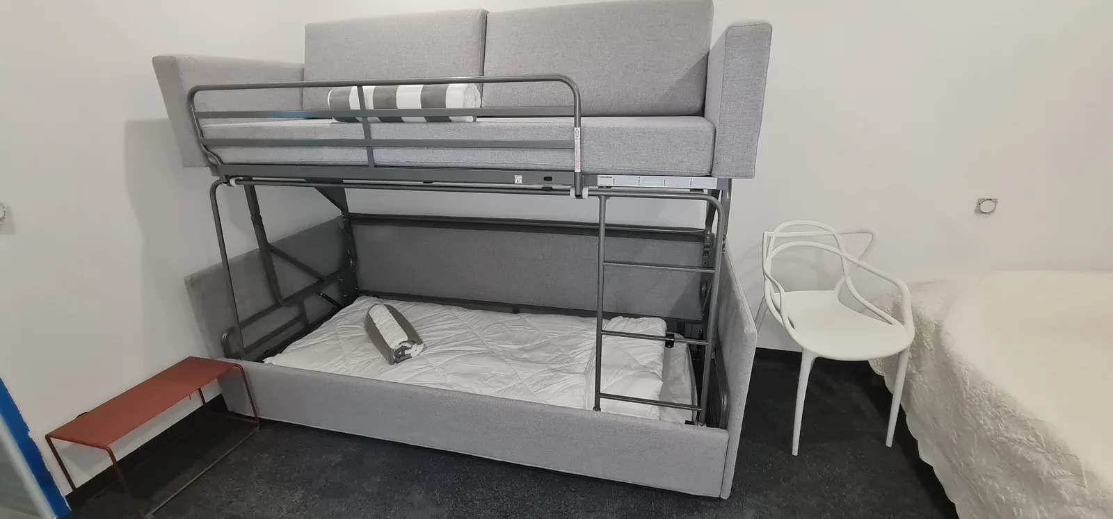 Dortoir avec lit superposé au cadre métallique gris et chaise design blanche
